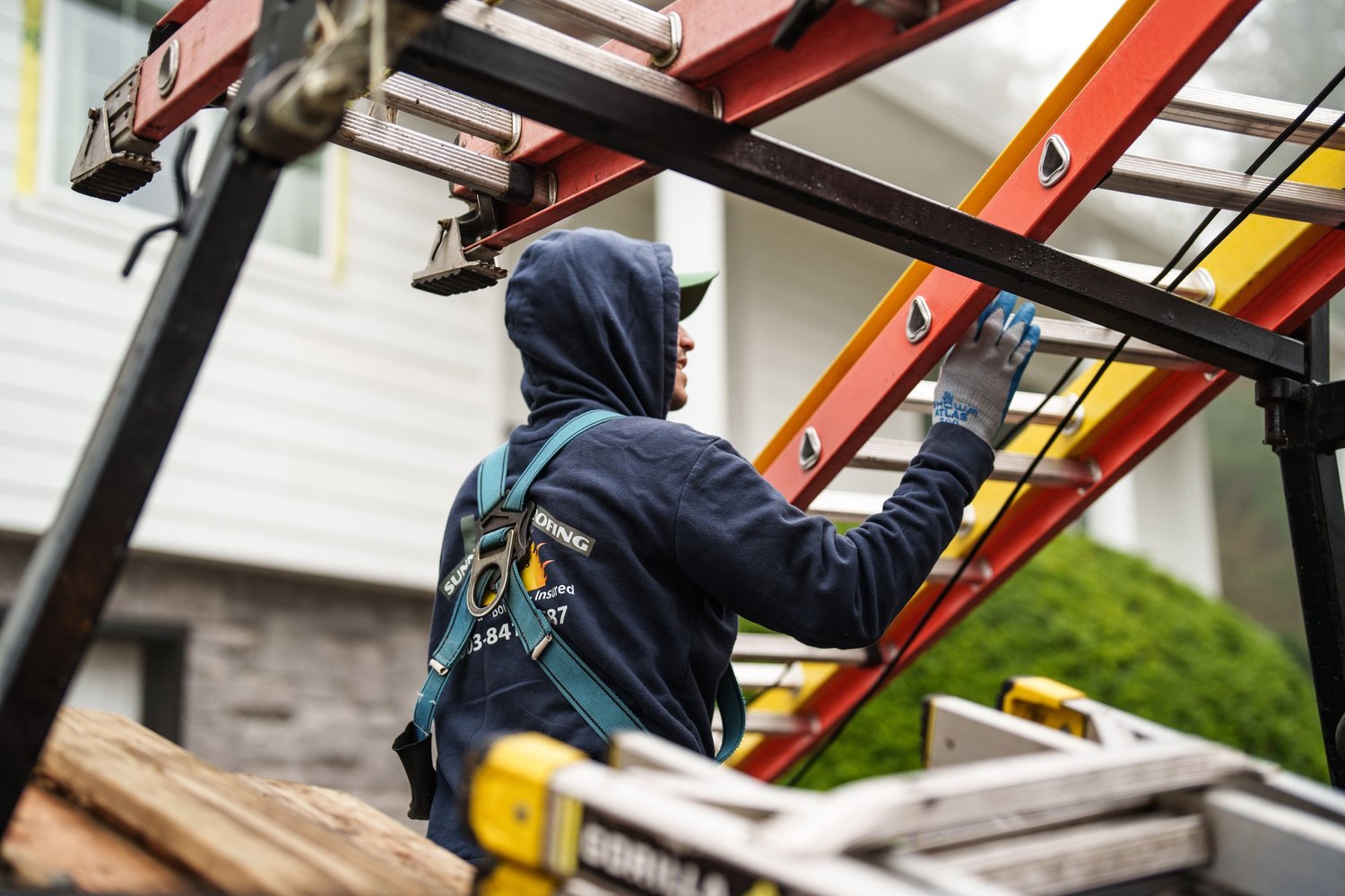 Sunnyside Roofing worker on ladder at a residential house