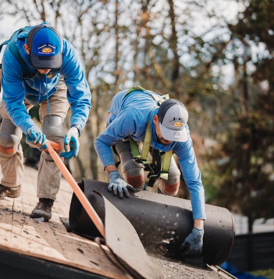Sunnyside Roofing workers unrolling felt roofing materials